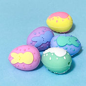 pastel silicone Easter egg beads with raised decorative details and rabbits on a pale blue background