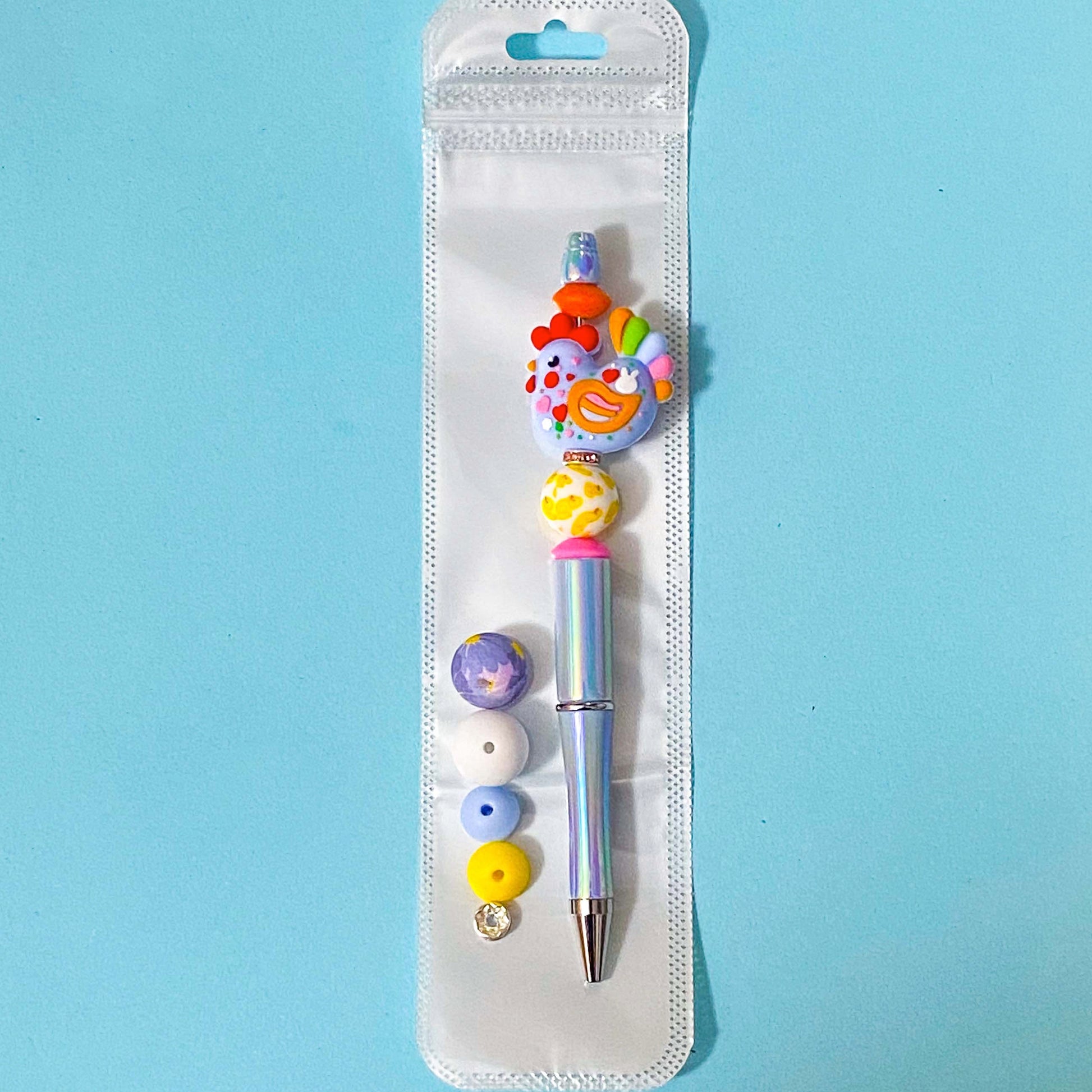 large colourful cockerel chicken beaded pen diy kit on a blue background