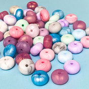 silicone chunky 15mm spacer abacus beads with pearlescent and marbled finish on blue background