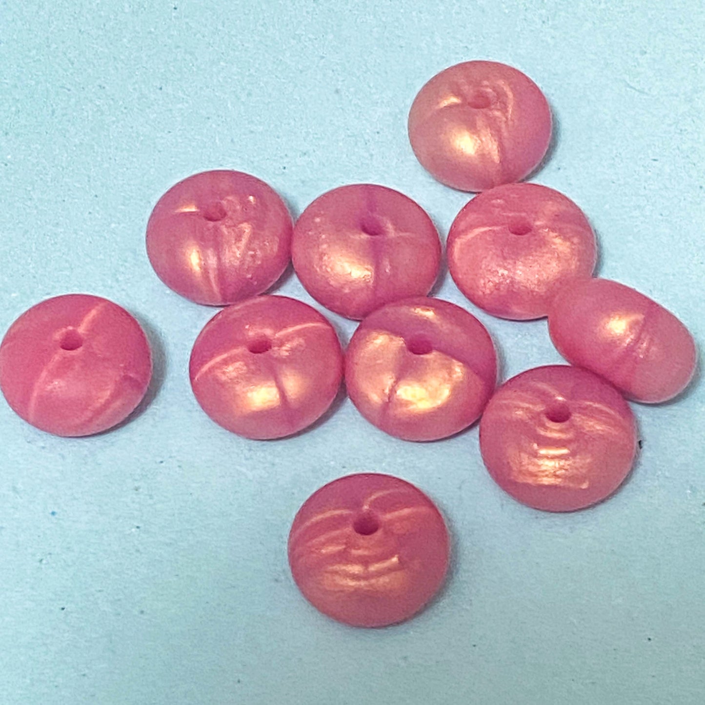 silicone spacer beads with a chunky shape in pearly rose gold on blue background