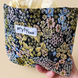 beautiful woven floral tapestry pouch with cream lining, concealed zip- finish and gusseted base. English garden at twilight themed pattern with daffodils, foxgloves, blue pink and yellow flowers. Perfect for cosmetics, stationery and everyday essentials.